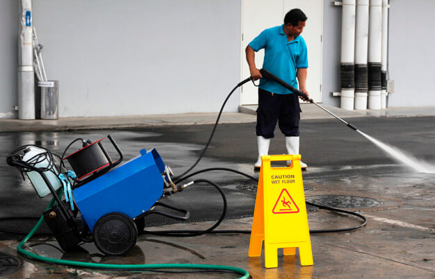 limpeza industrial homem lavando área externa